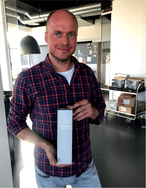 Unser Kollege Sebastian hält stolz den UX Award in den Händen, den er mit seinem Team für das Produkt STAT Diagcore von Qiagen erhalten hat. 