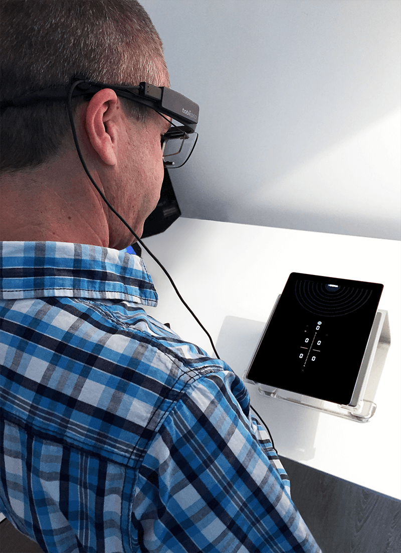 In our internal usability lab, a test person is testing the BORA Pure user interface on a tablet. The test persons wears eye-tracking glasses.