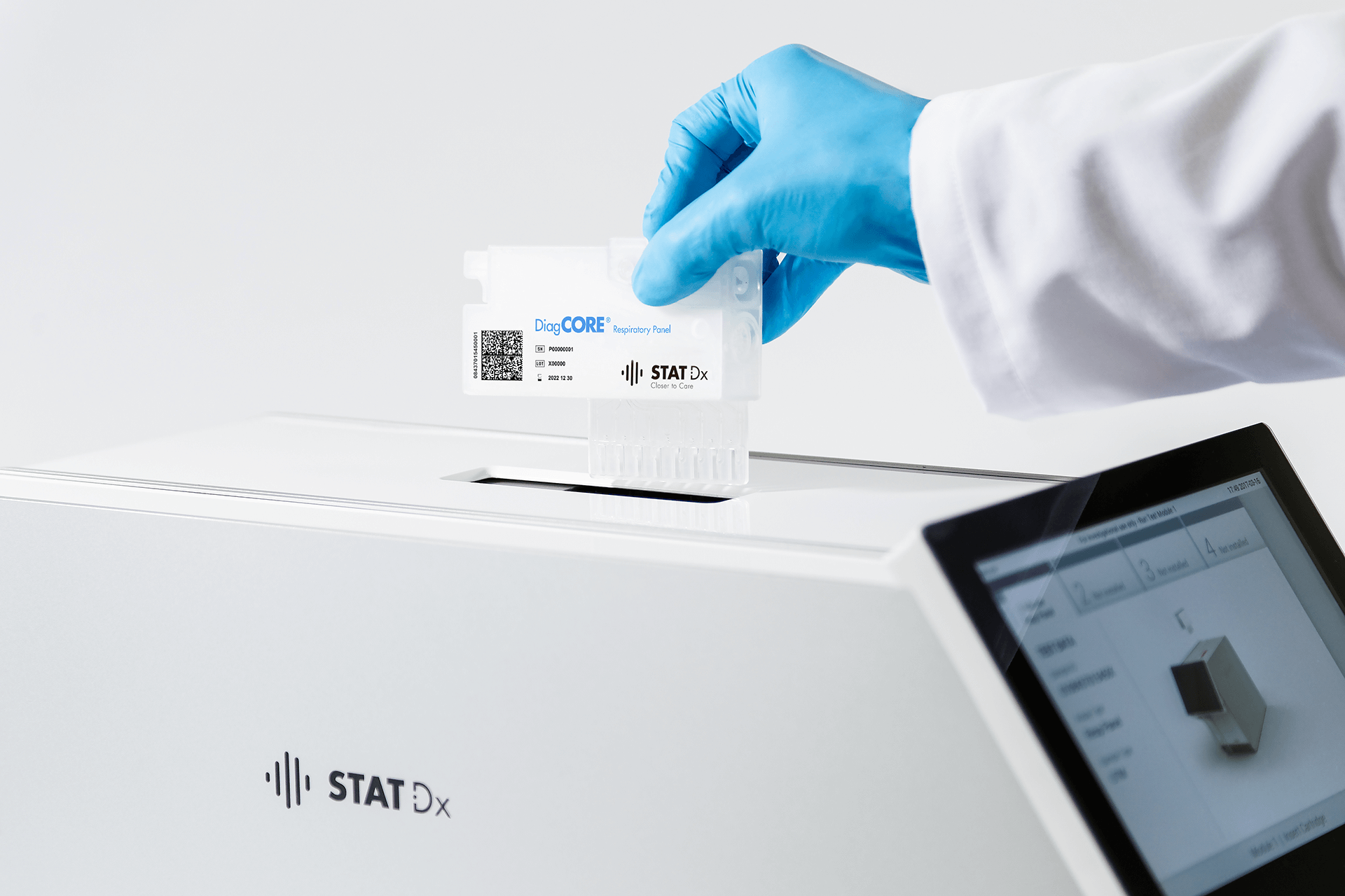 A laboratory assistant is placing a sample to be analyzed in Qiagen's QIAstat Analyzer.